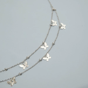 Detail view of a double-layered silver waist chain with delicate butterfly pendants