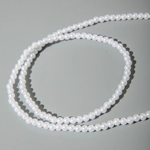 Detailed macro view of elegant white pearls on a minimalist multilayer metal body chain