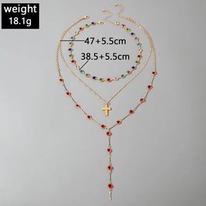 Three-layer gold necklace set featuring colorful crystals and a cross pendant detail