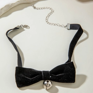 Detail of black velvet bow choker with a silver bell pendant and adjustable metal chain