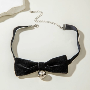 Detail of black bow choker featuring a silver bell and adjustable extension chain