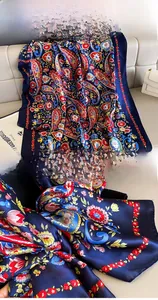 Detailed close-up of navy paisley silk shawl with premium stitched edges and vivid prints