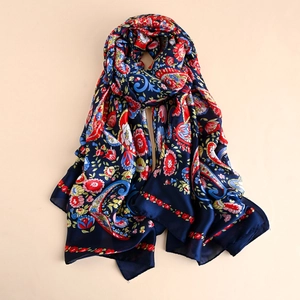 Macro detail of navy paisley silk scarf showing soft fabric texture and floral patterns