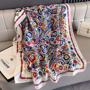 Detailed view of colorful paisley pattern on soft silk scarf draped on a modern sofa