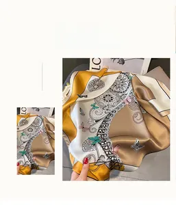 Vue détaillée d'un foulard en satin champagne doré avec motifs de papillons et dentelle