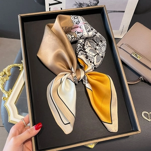 Carré de soie élégant champagne avec motifs de fleurs et papillons sur plateau déco