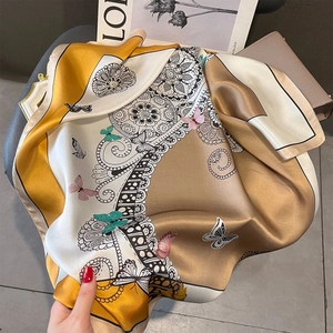 Carré de soie élégant avec motifs mandala jaunes et dorés sur un tissu drapé