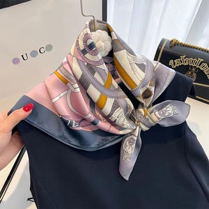 Silk square scarf featuring geometric pink and yellow horse print tied on neck with gift box