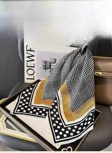 Detailed mulberry silk scarf featuring houndstooth pattern and yellow border on a handbag