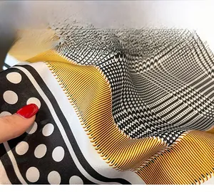 Macro shot showing refined hem stitching and geometric polka dot silk scarf texture