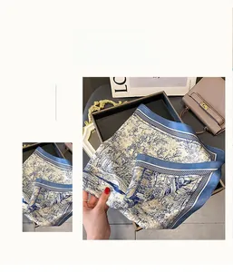 Detailed view of luxury silk scarf featuring traditional landscape ink painting in blue and gold