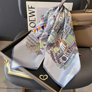 Premium mulberry silk square scarf with blue vintage patterns draped on a handbag