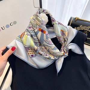 Close-up of a multi-color geometric silk scarf tied on a black sleeveless dress