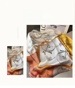 Détail d'un foulard en soie avec motif vélo vintage et bordure chaîne orange