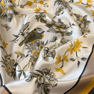 Vintage floral silk scarf with bird prints and golden accents in elegant folded texture