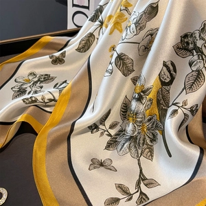 Detailed macro view of vintage silk scarf showing floral prints and satin texture