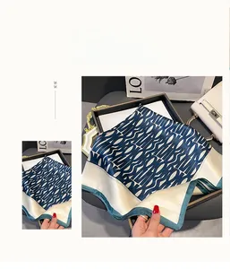 Detail of silk square scarf showing luxury geometric patterns and smooth satin texture