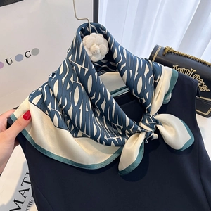 Luxurious navy and beige silk scarf featuring abstract patterns and floral accessory
