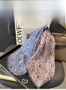 Dettaglio di foulard in seta di gelso a fiori drappeggiati su borsa e accessori di moda