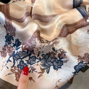 Elegant silk scarf with blue floral prints and vintage lace patterns on champagne satin