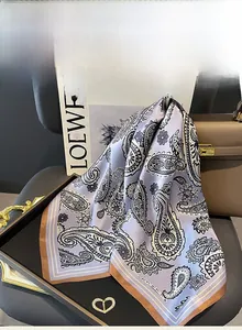 Detailed texture of lavender paisley mulberry silk scarf displayed on a luxury tray