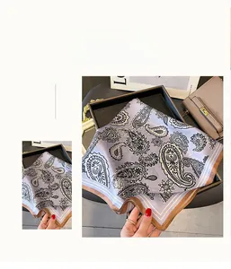 Detail of silk square scarf featuring paisley pattern and elegant mauve border texture