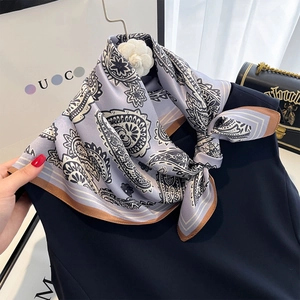 Classic silk scarf with paisley pattern styled on elegant black sleeveless top