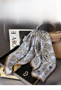 Gros plan sur un foulard en soie bleu clair à motif paisley sur un sac en cuir