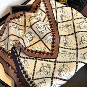 Detailed view of silk twill scarf with equestrian horse prints and checkered borders
