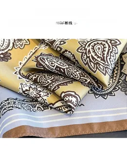 Gros plan détaillé du foulard en soie à motif paisley avec bordure à coutures premium