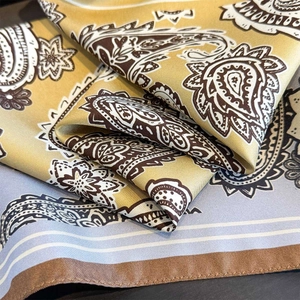 Vue détaillée d'un foulard en soie de luxe avec motif paisley et texture lisse