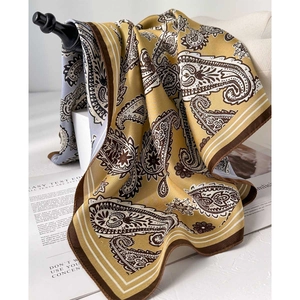 Foulard en soie doré à motif paisley élégamment drapé avec une texture satinée brillante