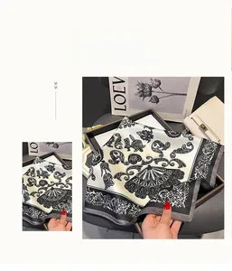 Detail of printed 100% mulberry silk scarf with ornate black and white floral patterns