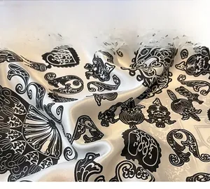 Detail of silk scarf showing precise edge stitching and retro black floral patterns