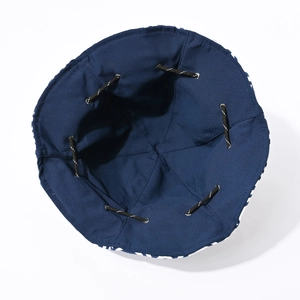 Detail showing deep blue bucket hat interior with adjustable drawstring and metal eyelets
