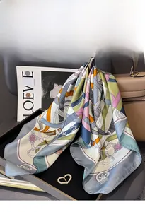 Detail of color-block silk twill scarf with retro horse bridle patterns on black tray
