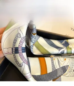 Macro detail of silk scarf showing refined triangle stitching and equestrian patterns