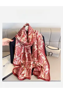 Détail d'un foulard en soie à motif vintage rouge et blanc drapé sur un blazer noir chic