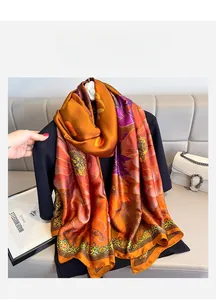 Detail of floral printed long silk scarf with baroque gold borders and rich warm colors