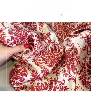 Détail du tissu en faux soie damas rouge avec texture respirante et douce pour la peau