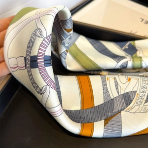Close-up of equestrian chain print silk scarf with luxury leather buckle details