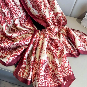 Écharpe en soie à imprimé damas rouge châle satiné élégant sur fond de cuir gris