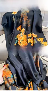 Detail of floral print silk scarf featuring premium stitching and glossy fabric texture