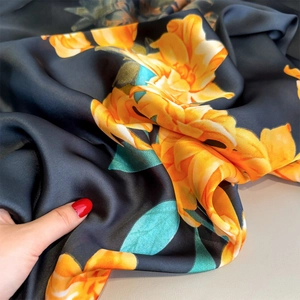 Elegant black silk-like scarf with large yellow floral prints and a satin finish luster