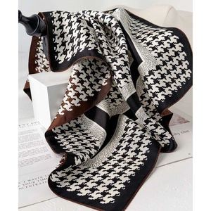 Classic houndstooth silk scarf in black white and brown draped on a pedestal