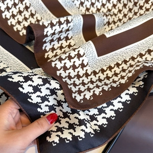 Detail shot of houndstooth silk scarf showing delicate texture and fine hemmed edges
