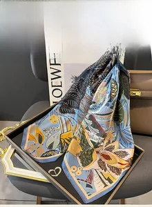 Detailed close-up of blue mulberry silk scarf with yellow tropical floral patterns