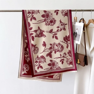 Detail of red rose and houndstooth pattern scarf with fine tassel edges on display