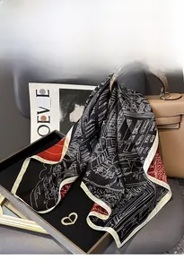 Detail of silk twill scarf with architectural print draped over a brown leather bag