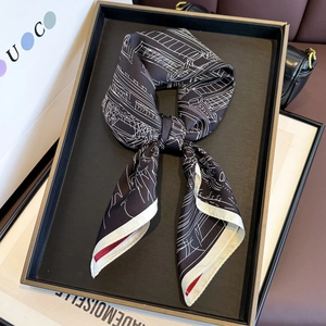 Elegant silk scarf with black and white architectural sketch patterns tied in a bow